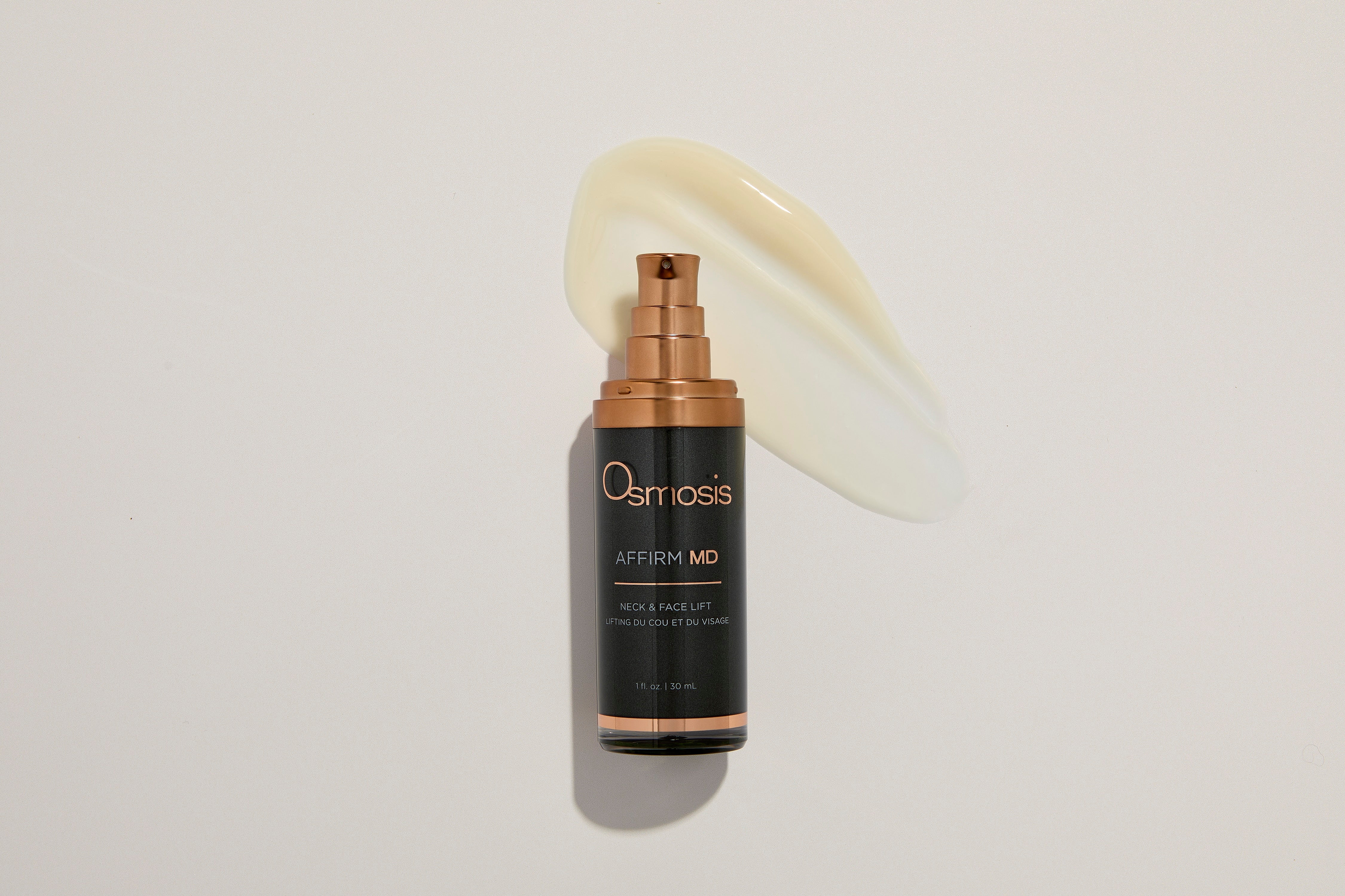 Black skincare bottle with copper trim with a off white product swap behind it.