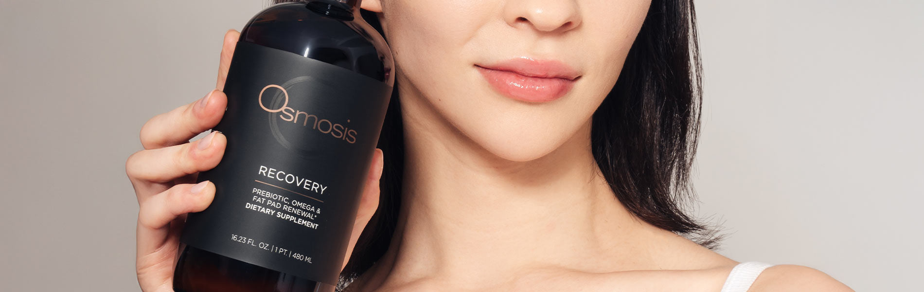 Woman holding a bottle of Osmosis Recovery