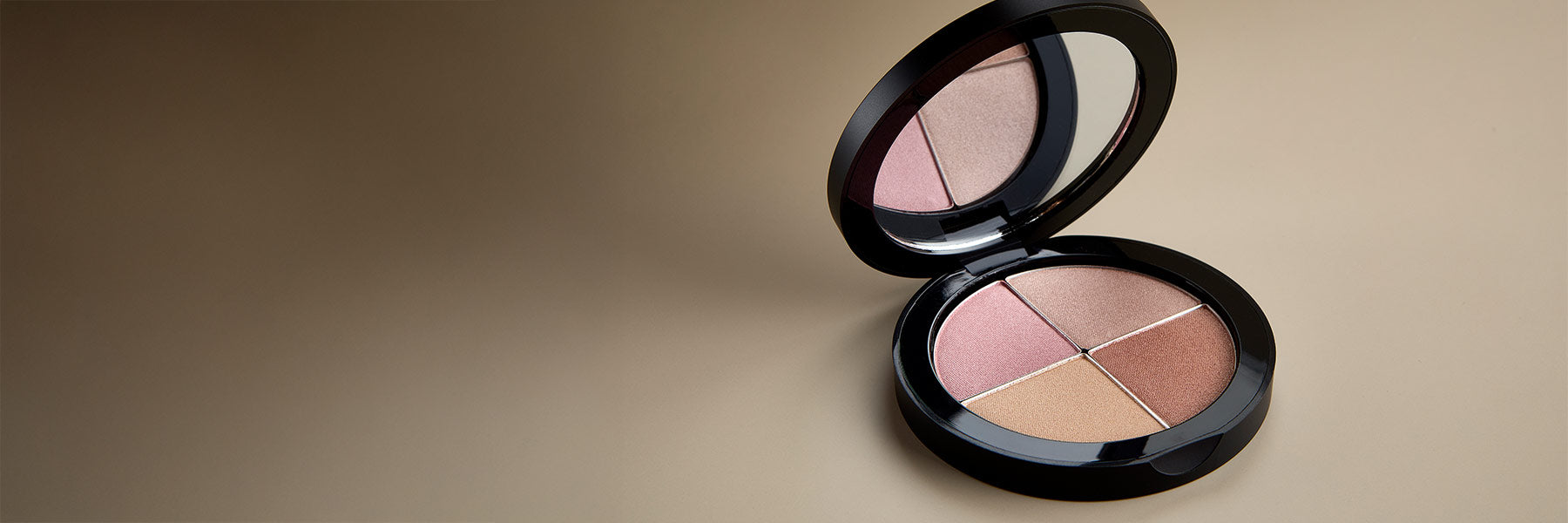 Osmosis Highlighting Quad - Makeup palette with four shades on a beige background