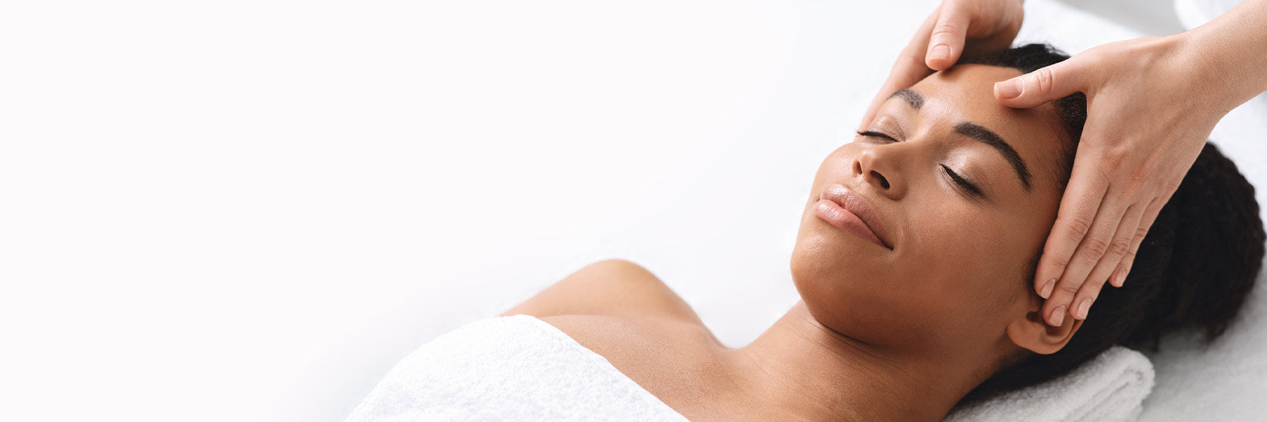 Woman receiving a head massage with a white background