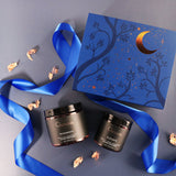 Cosmetic jars with decorative box and blue ribbon on a gray background