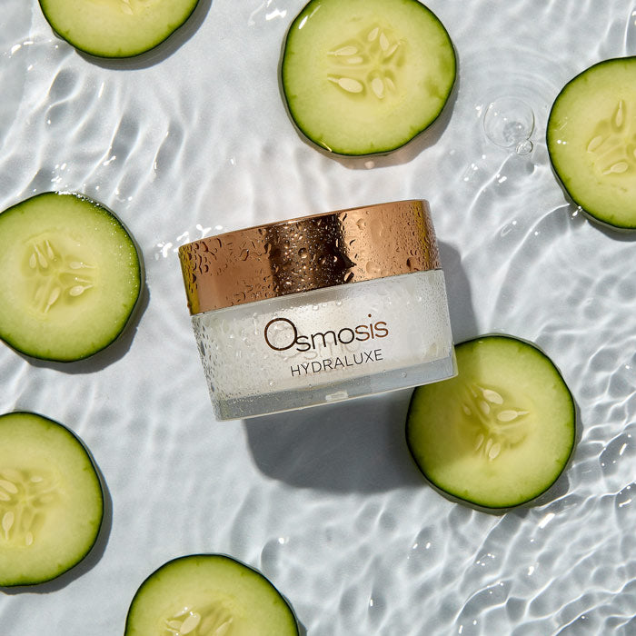 Osmosis Hydraluxe jar surrounded by sliced cucumbers on a water surface