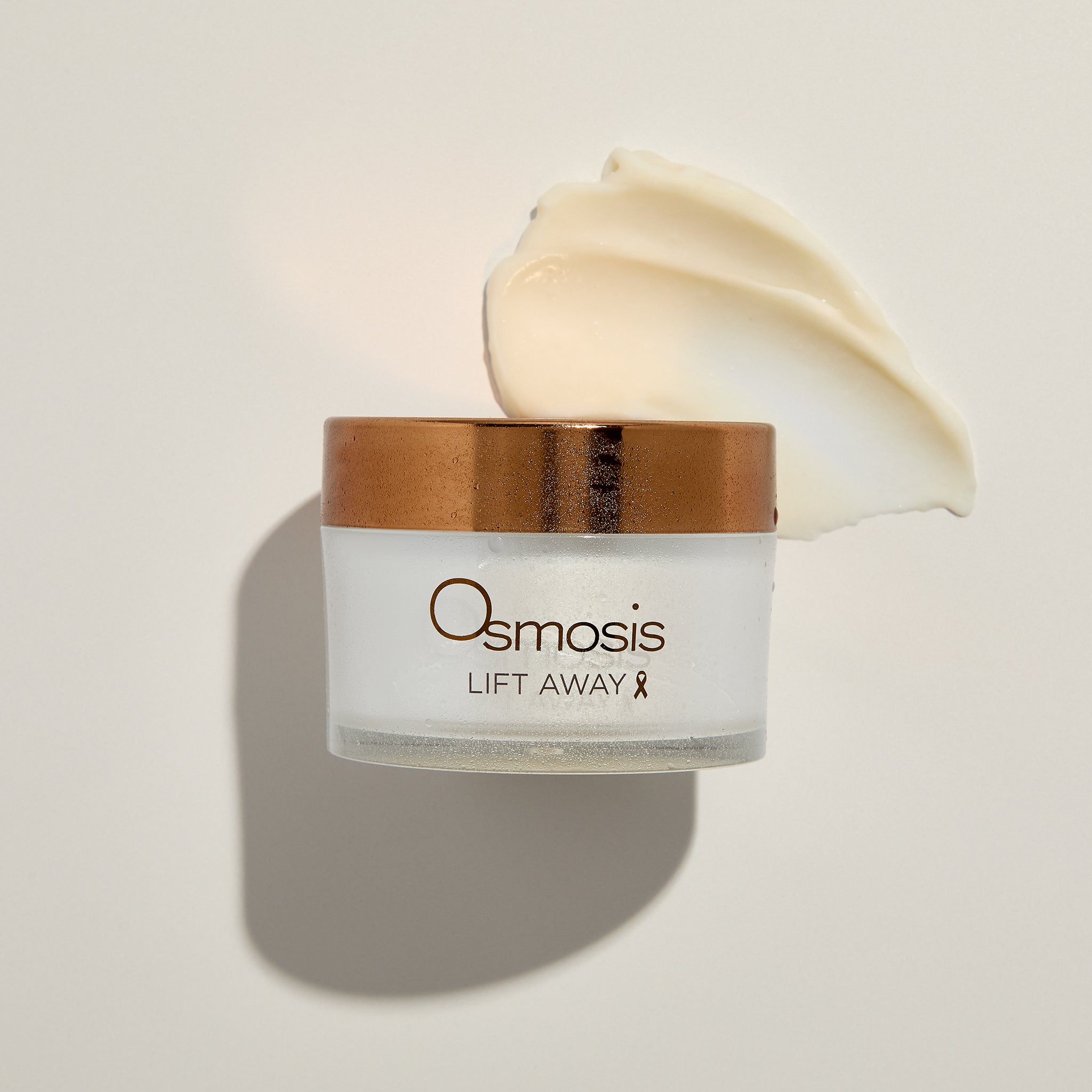 Osmosis Lift Away Cleansing Balm with product swatch and water mist on a beige background
