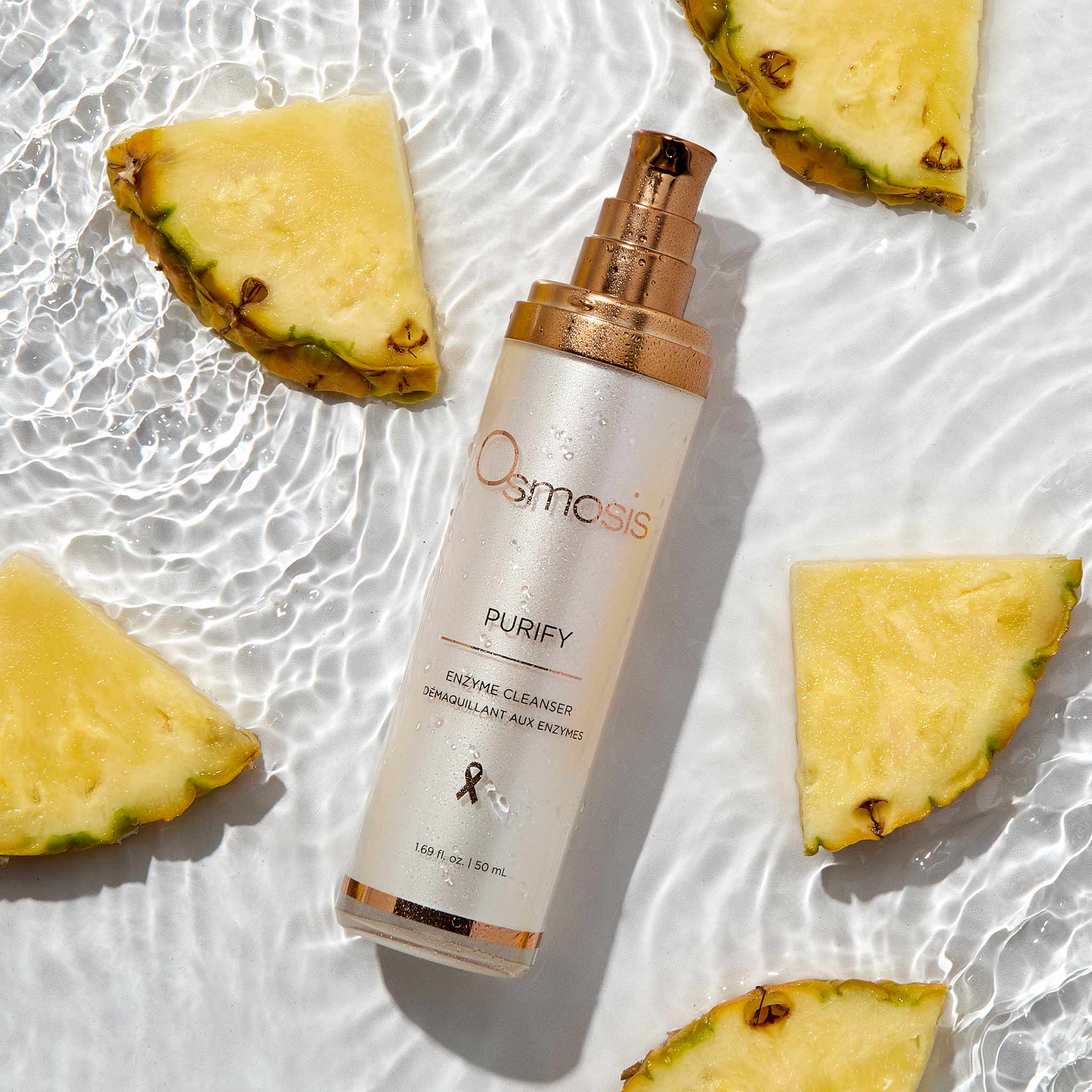 Osmosis Purify bottle with pineapple slices on a textured white background