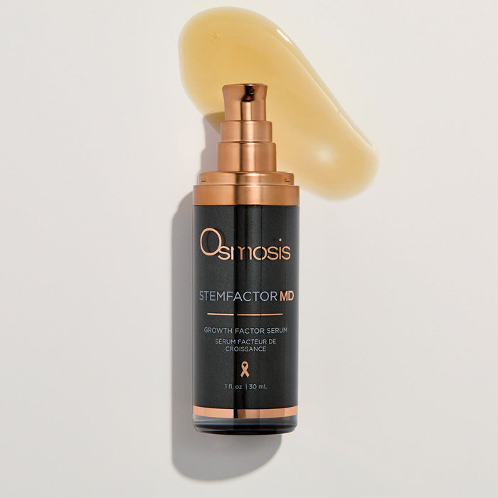 Osmosis Stemfactor MD serum bottle with a droplet of product on a light background