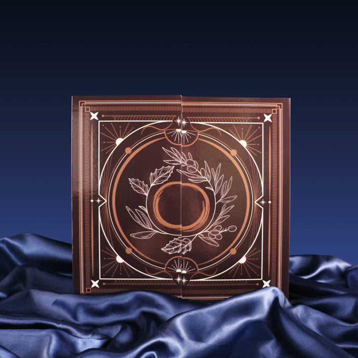 Decorative book with intricate design on a dark blue fabric background