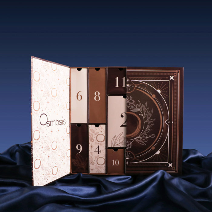 Osmosis skincare advent calendar with open doors on a dark blue fabric background