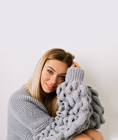 Blonde haired woman in grey chunky sweater