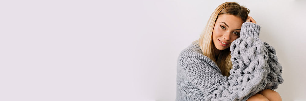 Blonde haired woman in grey chunky sweater