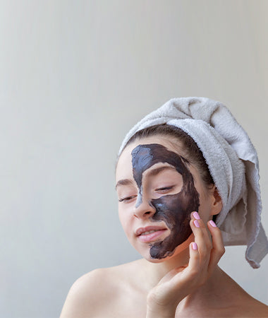 Woman with a charcoal mask on half her face