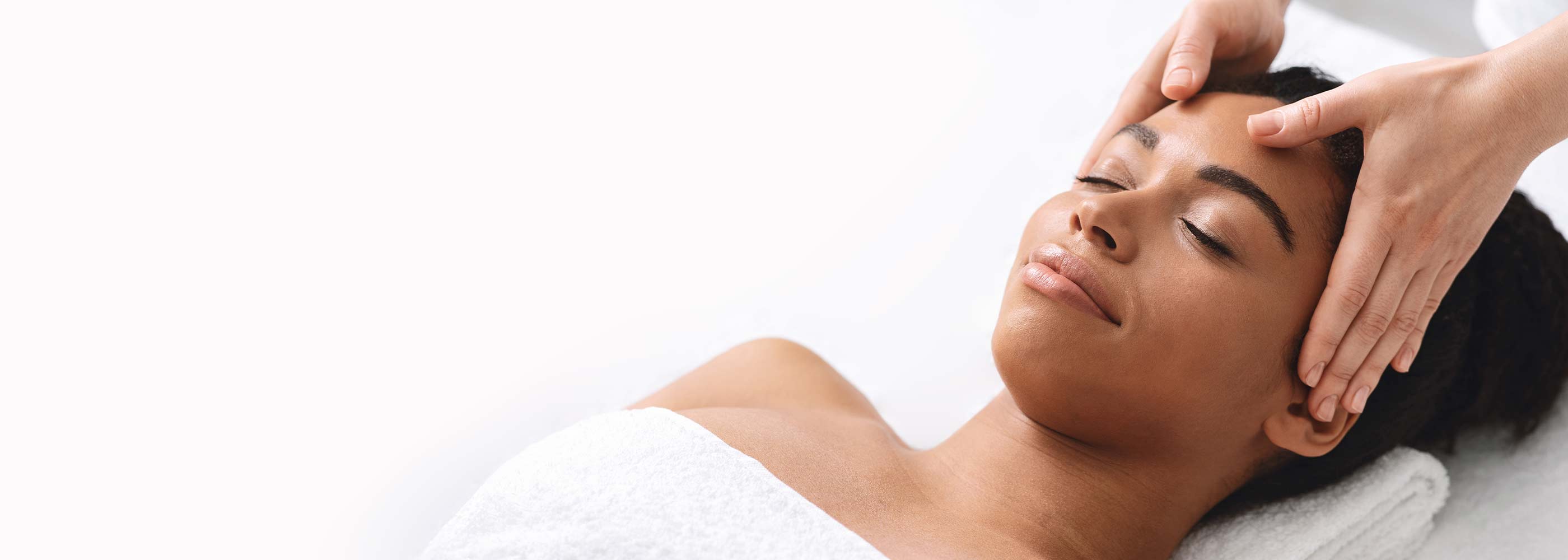Woman receiving a head massage with a white background