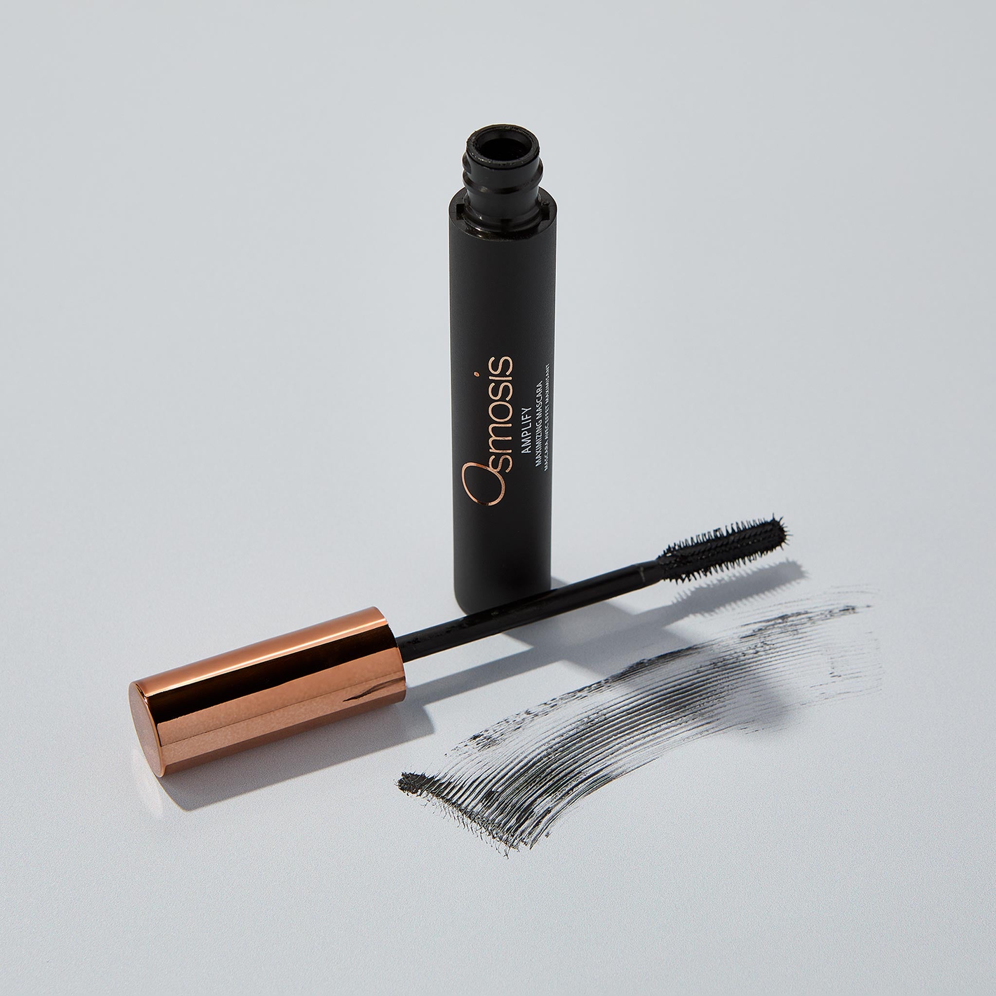 Osmosis Amplify Maximizing Mascara with product swatch on a gray background