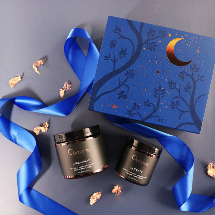Cosmetic jars with decorative box and blue ribbon on a gray background