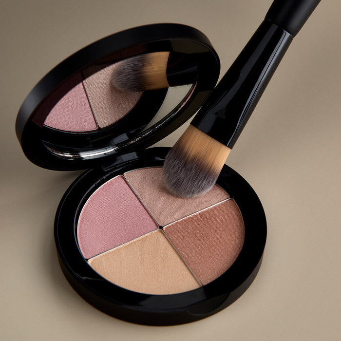 Osmosis Highlighting Quad - Makeup palette with four colors on a tan background with Osmosis Dual Foundation Brush