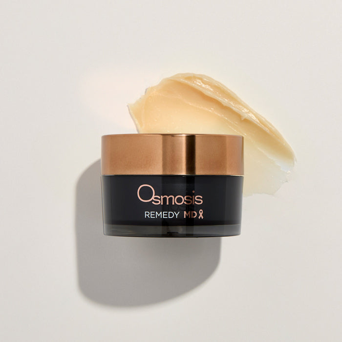 Osmosis Remedy MD jar with a smear of cream on a light background