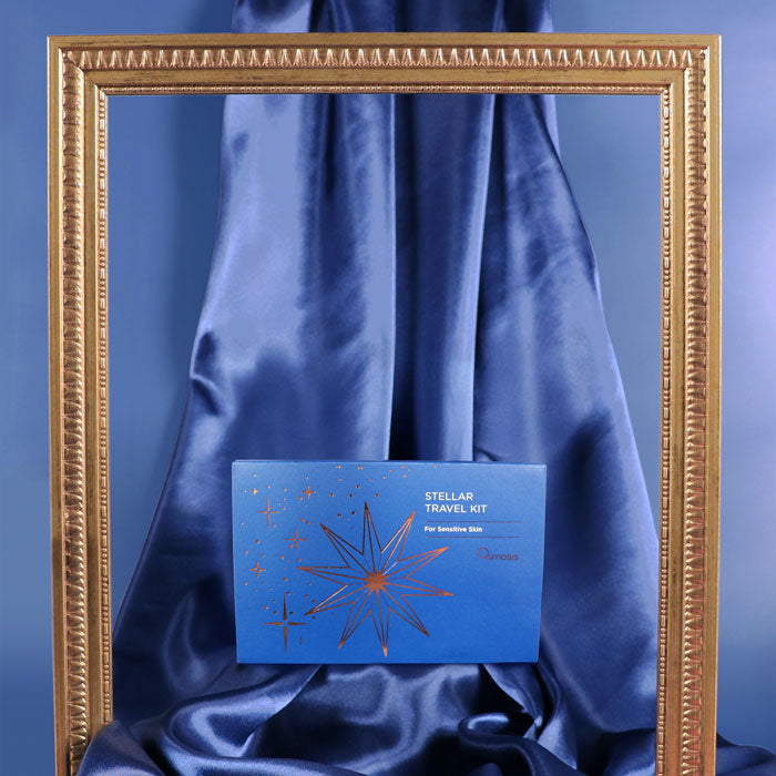Blue Stellar travel kit on a blue fabric background with a gold frame