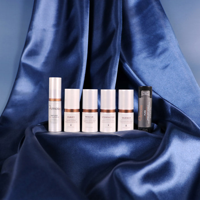 Set of skincare products on a blue satin background